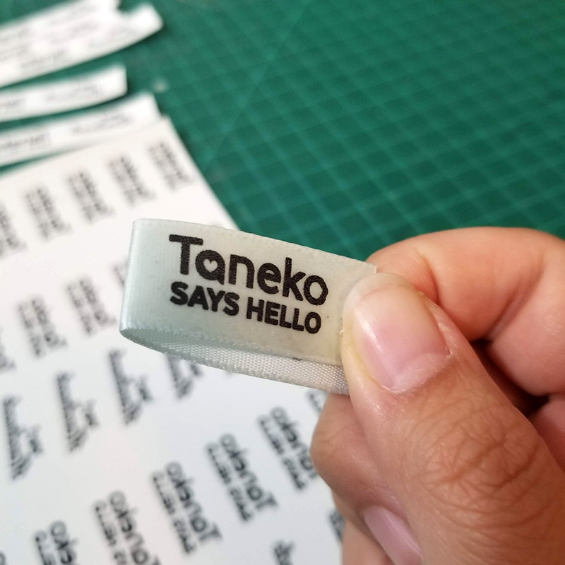 handmade ribbon tags for plush toys featuring Taneko Says Hello logo