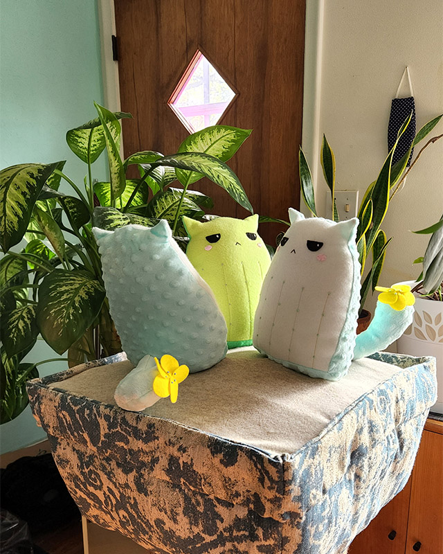 work in progress fiber art sculpture with 3 Cactus Cat plushies