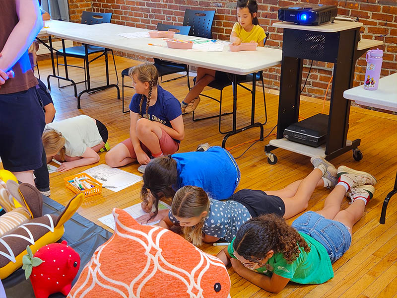summer art camp kids making art on the floor in a group